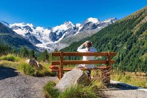 en äldre turist iakttar bergen från en bänk foto