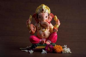 hinduisk gud ganesha. ganesha idol på mörk trä bakgrund. foto