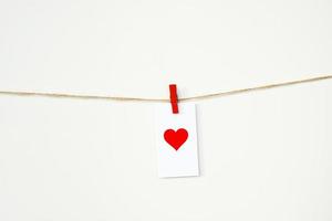 alla hjärtans dag-kort med rött hjärta hängande på ett rep på klädnypa. 14 februari kärlek bakgrund foto