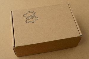 kartong med inskriptionen handgjord. en låda med handgjorda läderprodukter foto