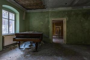 grönt rum med ett piano i ett gammalt hus foto