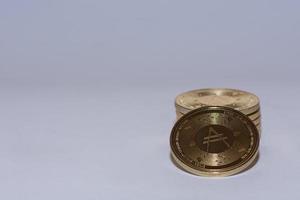 hög med gyllene värdefulla ada-mynt från kryptovaluta med grått foto