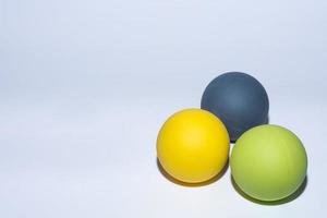 tre olika färgade bollar för massage på grått foto