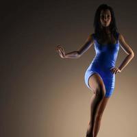 sexig brunett kvinna poserar i mörk studio foto