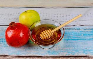 rosh hashanah jewesh semester honung, äpple och granatäpple över träbord. traditionella symboler. foto