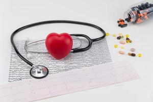 stetoskop på kardiogram och leksakshjärta. koncept sjukvård. kardiologi - vård av hjärtat foto