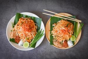 woka nudel pad thai på tallrik serverad på matbordet mat, thailändsk mat stekt nudel thai stil med räkor böngroddar och garnering jordnötter chili pulver socker citron lime - ovanifrån foto