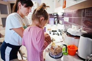 mamma med barn som lagar mat i köket, glada barns stunder. foto