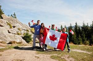 glad kanada dag. familj med stort kanadensiskt flaggfirande i bergen. foto