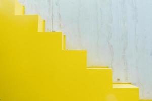 minimalistiska geometriska former i arkitektur. gula trappsteg och trasiga vita väggar. begreppet enkelhet i design. foto