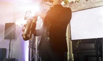 musiker saxofonist man i kostym spelar jazz foto