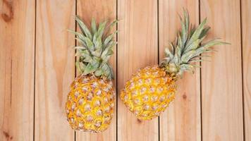 två ananas på en trä bakgrund foto