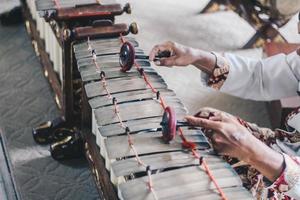 en man hand använda batik spelar gamelan gender eller slenthem. foto