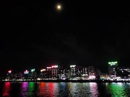 månbelyst natt vid stadens flod foto