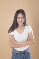 ett porträtt av asiatisk kvinna med vit t-shirt över ljusbrun bakgrundsstudio foto