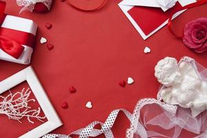 kuvert, gåva, hjärta, ros, ängel, band för alla hjärtans dag lägenhet låg på röd bakgrund med kopia utrymme foto
