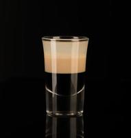 snapsglas med alkohol på en mörk bakgrund foto