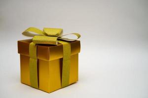 gyllene presentförpackning på ljus bakgrund foto