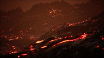 röd orange levande smält lava som rinner ut på grå lavafält och glänsande stenig mark foto