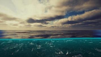 delad vy över och under vatten i Karibiska havet med moln foto
