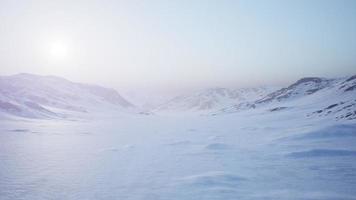 flyglandskap av snöiga berg och isiga stränder i Antarktis foto