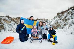 skandinavisk familj med Sveriges flagga i svenska vinterlandskap. foto