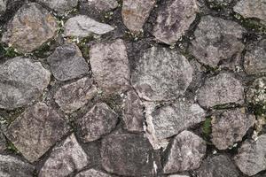 abstrakt traditionell stenmur trottoar textur bakgrund. ojämn strukturerad stenvägg gjord av stenplattor och plattsten. foto