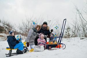 skandinavisk familj med Sveriges flagga i svenska vinterlandskap. foto