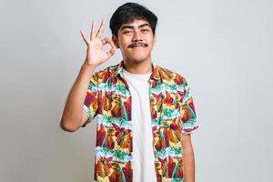 asiatisk man med mustasch leende positivt gör ok tecken med hand och fingrar foto