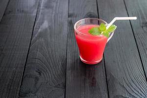 vattenmelon smoothies toppning med färska myntablad foto