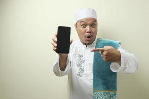feta asiatiska muslimska män ser förvånade över de goda nyheterna på telefonen foto