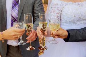 bruden och tärnorna firar att dricka champagne från glas foto