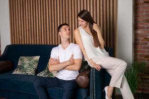 leende kaukasiska man och kvinna kramas på soffan, spendera romantisk intim foto