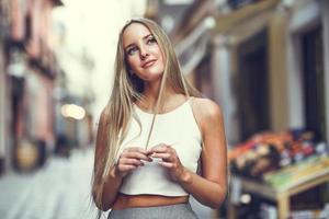 vacker ung blond kvinna i urban bakgrund. foto