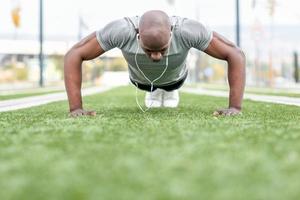 fitness svart man utövar armhävningar i urban bakgrund foto