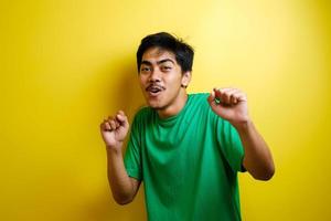 asiatisk man i grön t-shirt ler och dansar glatt foto