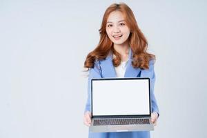 ung asiatisk affärskvinna som använder bärbar dator på vit bakgrund foto