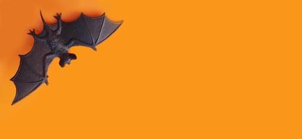 halloween banner. statyett av en fladdermus på en orange bakgrund, kopieringsutrymme, plats för text. djur, flygblad, inbjudan foto