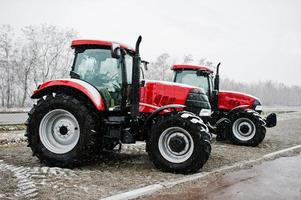 två nya röda traktor stannar vid snöväder foto