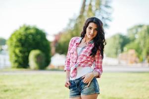 porträtt av stil land flicka på korta jeans shorts och crosscountry rutig linje skjorta foto