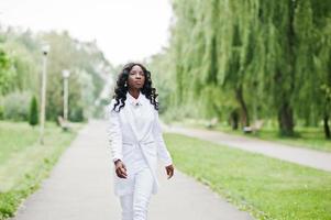 snygg svart afrikansk amerikansk flicka går på vägen i parken foto