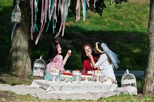 tre tjejer matade varandra med tårta och jordgubbar på svensexa foto