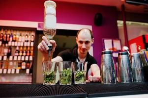 bartendern förbereder mojito cocktaildrink i baren foto