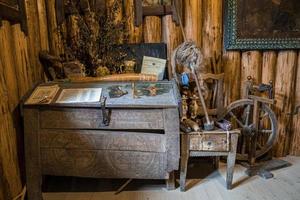 stängd kista med antika verktyg på trästol i övergivet rum foto