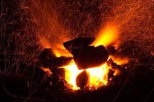 kolbränning i en grill. Brinnande eld. eldslåga. foto