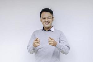 ung asiatisk man bär grå skjorta med glada leende ansikte och tummen upp eller ok tecken foto