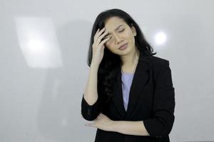 affärs ung asiatisk flicka är stress och förvirrar om sitt arbete isolerad på vit bakgrund foto