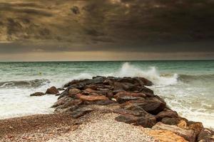 storm över vågbrytarna på stranden. horisontell bild. foto