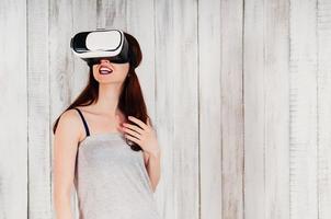ganska ung kvinna bär virtuell verklighet glasögon, upphetsat leende foto