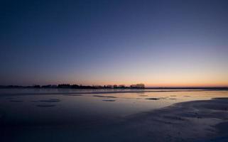 solnedgång på frusen sjö foto